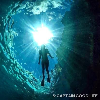 Snorkeler silhouetted against the light inside the cave