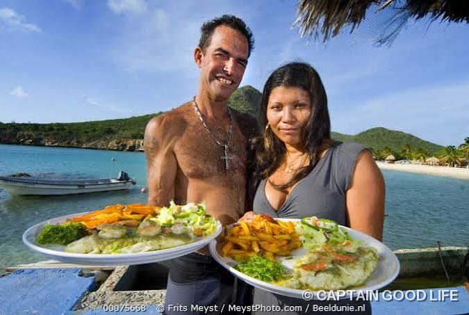 Mrs Goodlife's beach kitchen with two plates of freshly cooked fish