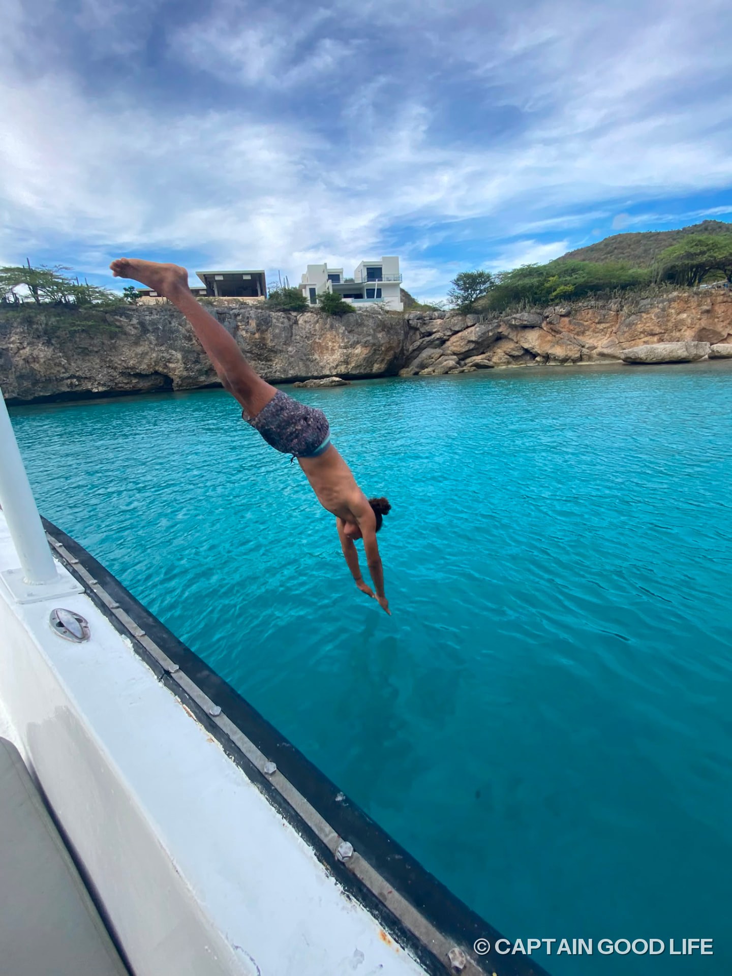 Diver jumping off the side of the boat into deep blue water